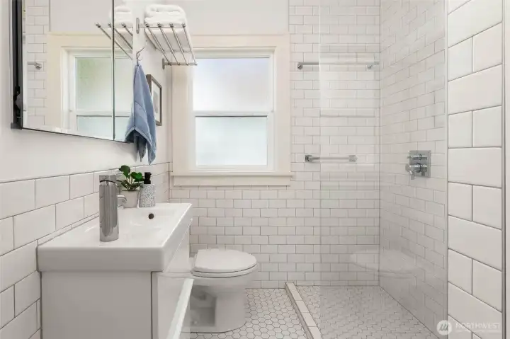 Upper level bathroom. Crisp and timeless with a walk in shower, subway tile walls and hex-tile floor.