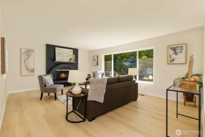 The living room is bright and warm with a wood burning fireplace and huge, sunny windows.