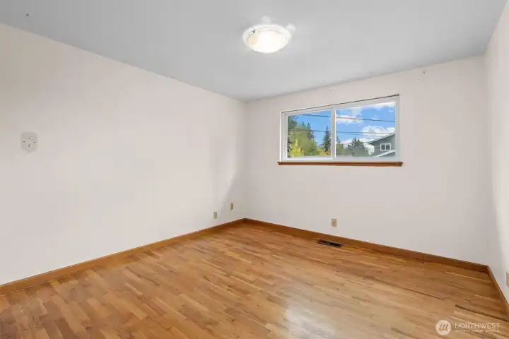 Guest Room #1, complete with hardwood floors.  These floors run throughout the entire upstairs, currently being protected by carpet!