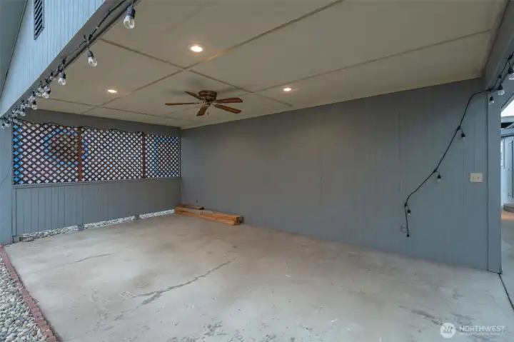 Covered patio has ceiling fan and lights.