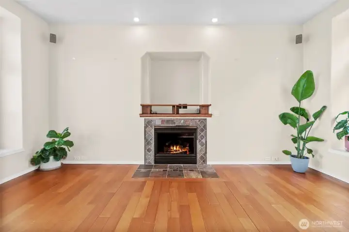 Gas fireplace with tile surround, hardwood floors, and a bright, open living space.