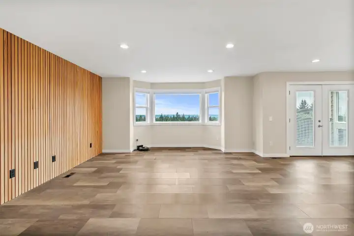 Living room with a designer slat wall, large view windows, and bright open space.