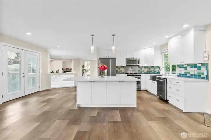 Updated kitchen with quartz counters, stainless appliances, tile backsplash, and a large island for easy prep and gathering.