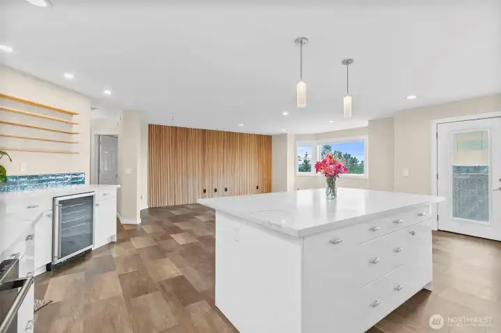 Updated kitchen with quartz counters, stainless appliances, tile backsplash, and a large island for easy prep and gathering.