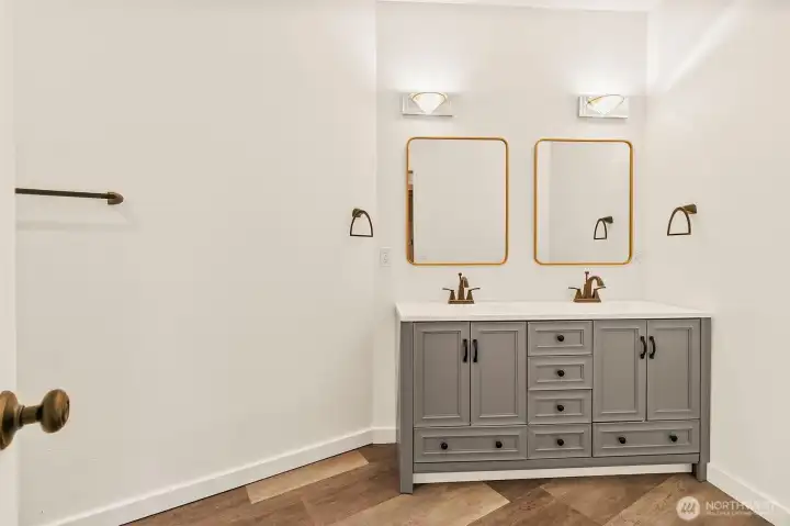 Updated bathroom with dual-sink vanity, modern mirrors, and clean neutral finishes.