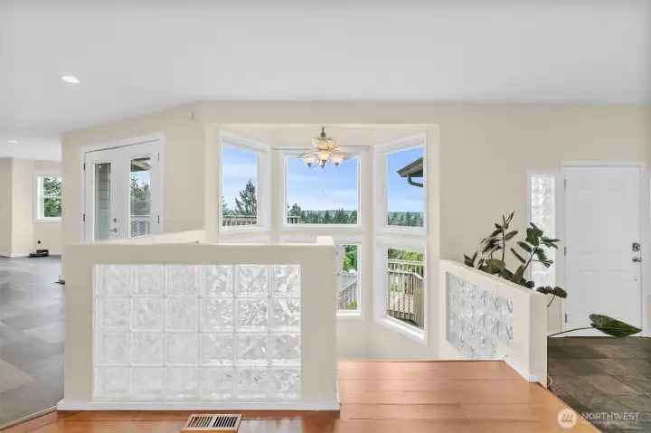 Entry area with glass block accents, front door, and large view windows near the stairs.
