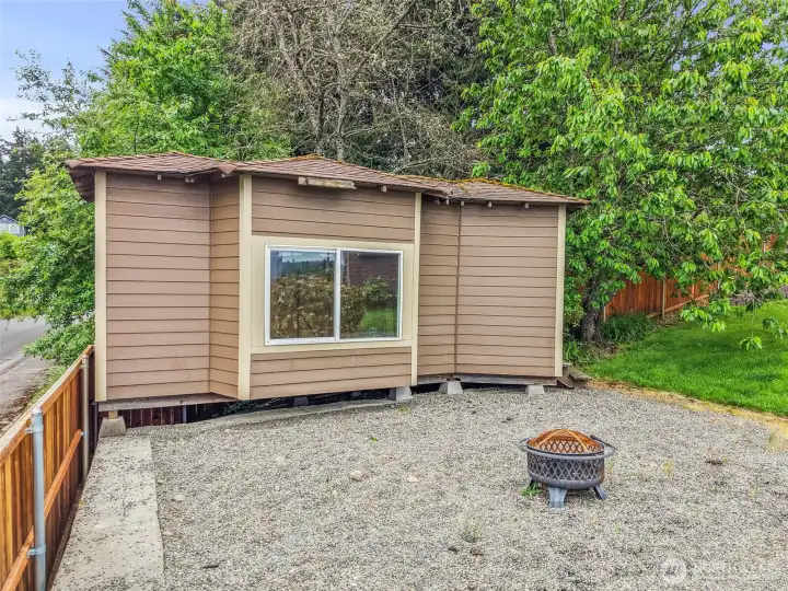 Storage shed with window, gravel area, and extra space for tools, yard gear, or seasonal items.