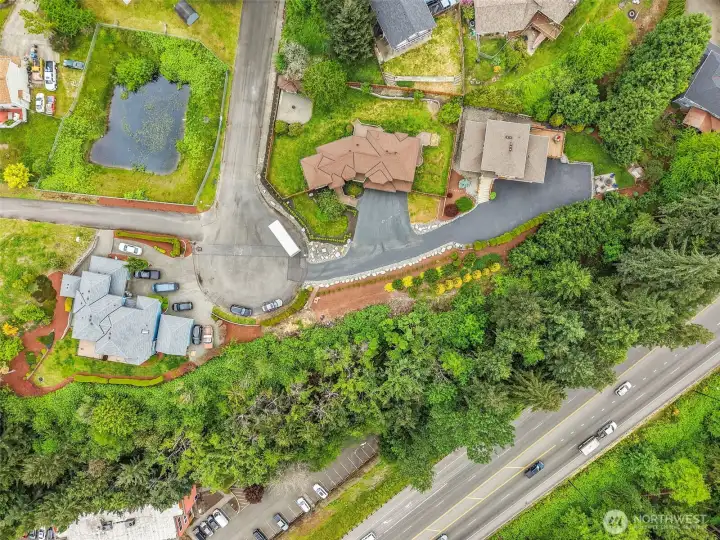 Overhead drone view showing the dead-end street, 0.33-acre lot, fully fenced yard, and nearby Hwy 410 access.