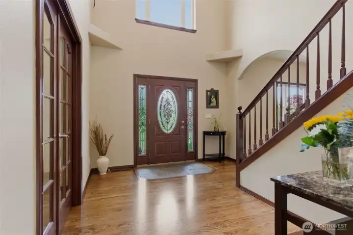 A grand front entry welcomes you with soaring ceilings, rich hardwood flooring, and a stunning entry door that sets the tone for the home’s custom craftsmanship