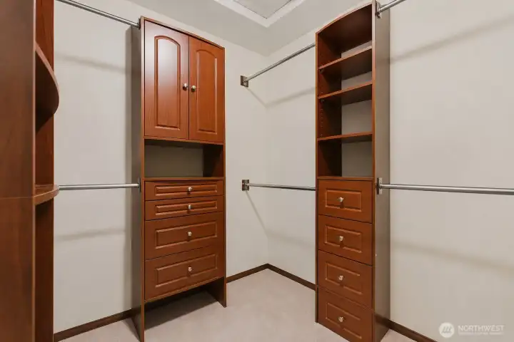 The oversized walk-in closet is beautifully appointed with rich custom organizers, abundant storage, and thoughtfully designed space for an extensive wardrobe