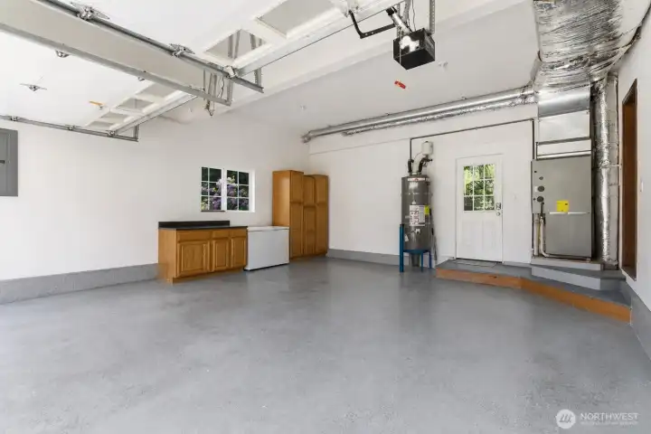 The spacious garage offers excellent storage and organization with included built-in cabinetry and plenty of room for vehicles, tools, and hobbies