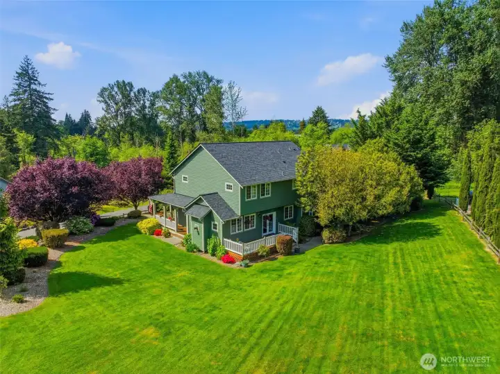 From every angle, the home showcases exceptional outdoor living with dual decks, mature landscaping, and sprawling lawn space across 1.05 usable acres