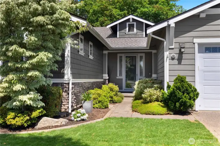 Covered front entry framed by established landscaping, stone accents and a welcoming walkway. Covered front entry framed by established landscaping, stone accents and a welcoming walkway.