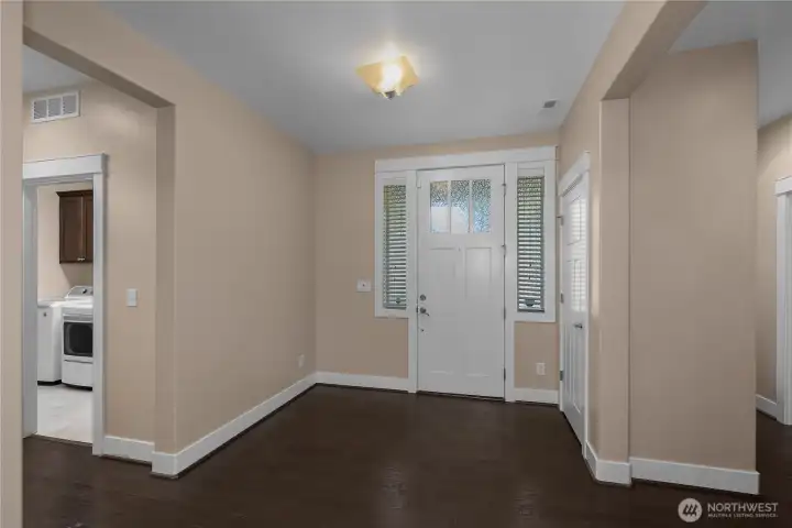 Spacious foyer with wood-plank flooring, crisp white millwork and decorative glass surrounding the front door. Spacious foyer with wood-plank flooring, crisp white millwork and decorative glass surrounding the front door.