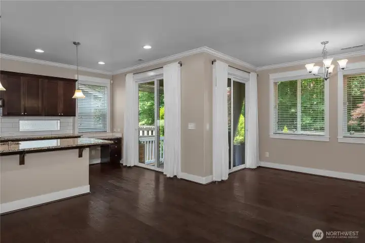 Open dining and kitchen areas feature two sliding glass doors leading to the covered outdoor living space. Open dining and kitchen areas feature two sliding glass doors leading to the covered outdoor living space.
