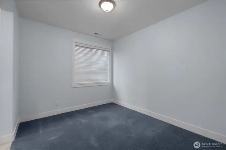 BR 2 - Comfortable secondary bedroom with soft blue walls, plush carpeting, a large window and white millwork. BR 2 - Comfortable secondary bedroom with soft blue walls, plush carpeting, a large window and white millwork.