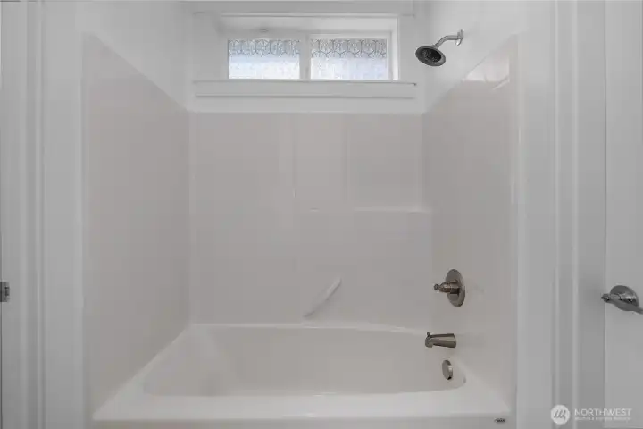 Jack and Jill Bath - Clean tub-and-shower combination with full surround, built-in shelving and a privacy window. Jack and Jill Bath - Clean tub-and-shower combination with full surround, built-in shelving and a privacy window.
