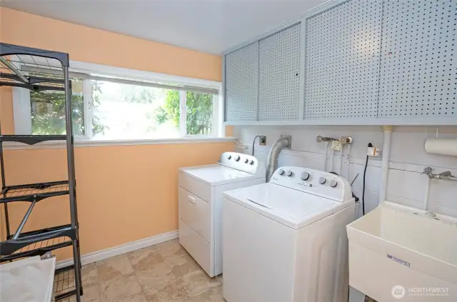 Function utility room with laundry sink and storage.