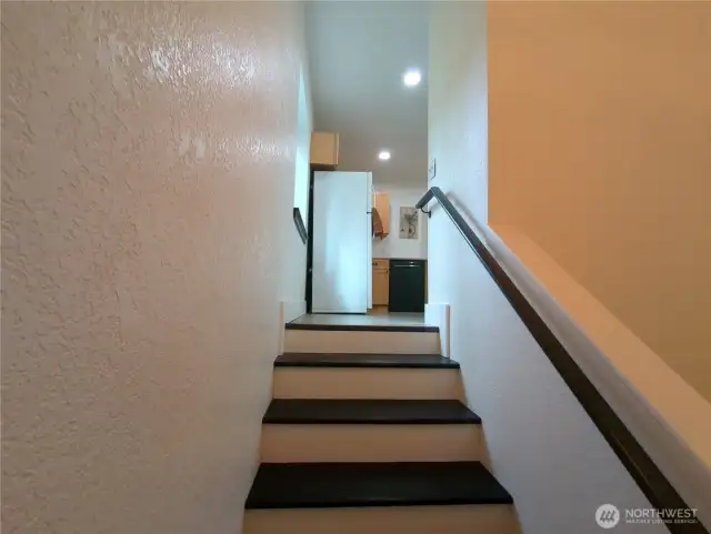 Stair case enters the kitchen area.