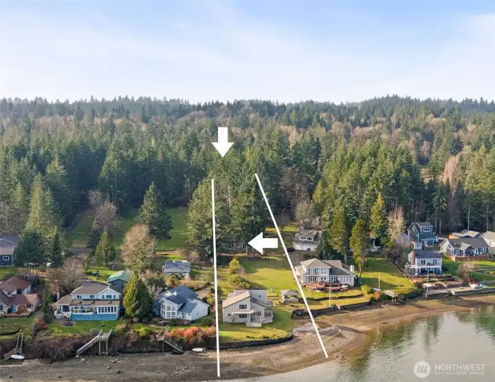 Three separate structures anchor this rare no-bank waterfront property with sweeping Puget Sound views. The arrow highlights the detached ADU, while the upper arrow indicates the detached garage/shop, illustrating the property’s flexible, multi-structure layout.