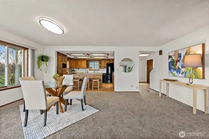 Open kitchen and dining space featuring an island with seating for casual meals or gathering.