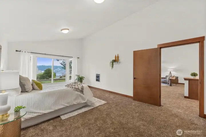 Spacious primary bedroom with French doors, new carpet, and water views.