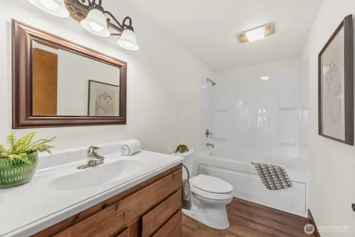 Full bathroom with LVP floors and a light, fresh feel.