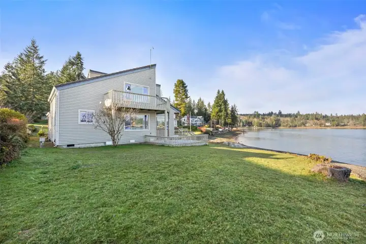 Three structures. No-bank waterfront. Endless potential. Main home, newer ADU, and a high-ceiling garage/shop for RVs or boats—all with water views and beach access on Puget Sound.