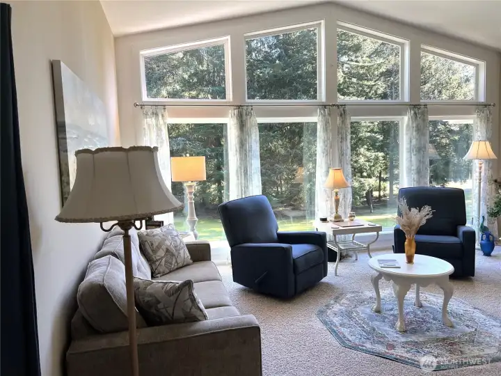 Living Room opens up to a bank of large windows overlooking the beautiful front yard and patio.