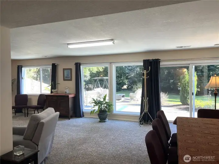 Large bank of floor to ceiling windows with views to the front yard and patio.