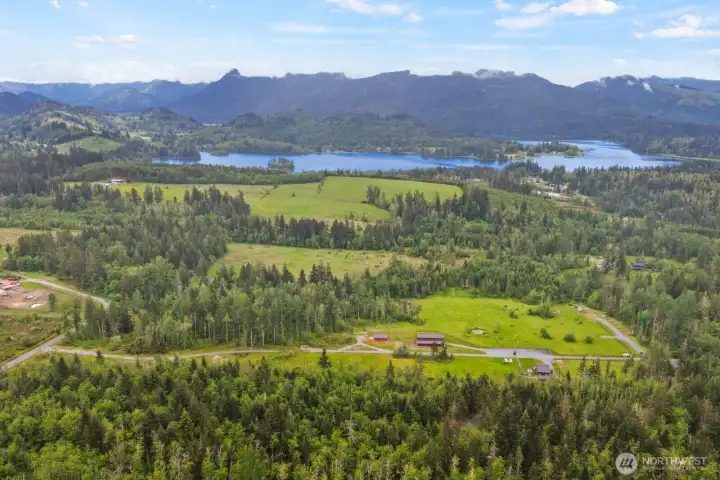 Sweeping drone view capturing nearby hills, open space, and the surrounding countryside.