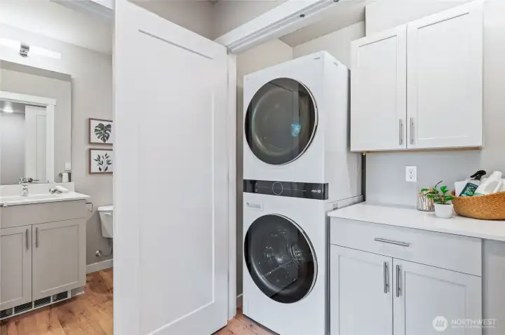 Large laundry center upstairs. Standard finish includes built in cabinetry and convenient folding station with quartz counter top.  Photos are of model home in the community.