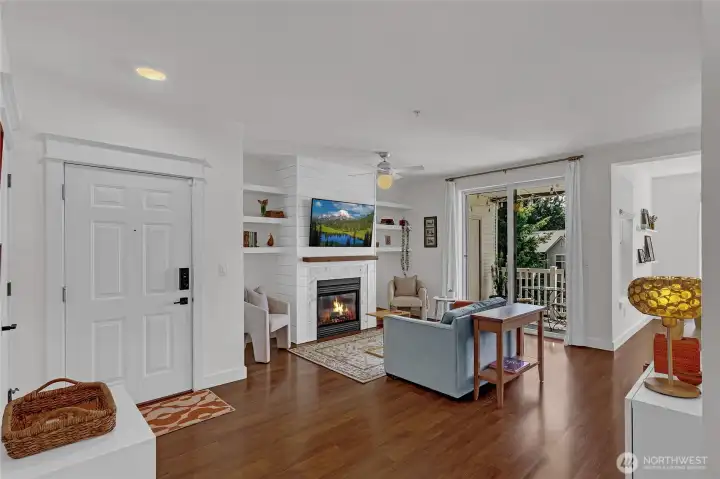 Featuring a cozy fireplace as the focal point, soaring natural light, and expansive windows that frame peaceful neighborhood views, this space feels both warm and spacious.