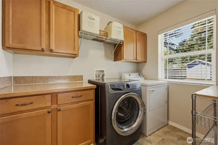 Just beyond the dining area is this well-appointed laundry room including cabinets, counter space, shelf w hanging bar, and large window for natural light! Washer and dryer included as well. Just beyond the dining area is this well-appointed laundry room including cabinets, counter space, shelf w hanging bar, and large window for natural light! Washer and dryer included as well.