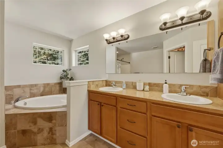 Double sinks in tall vanity, quality shaker cabinets, tiled jetted tub, and natural light make this inviting retreat. Double sinks in tall vanity, quality shaker cabinets, tiled jetted tub, and natural light make this inviting retreat.