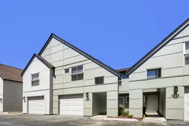 Modern curb appeal with a private entry and attached garage.