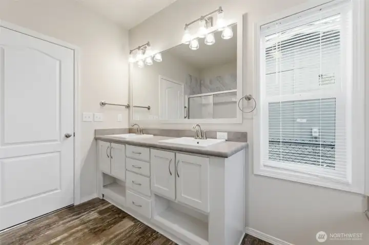 Primary bath features dual vanities, abundant storage, and elegant finishes for a clean, modern look.