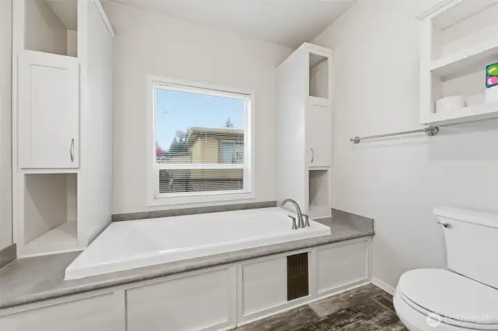 Relax and recharge in the deep soaking tub surrounded by convenient side shelving and natural light.