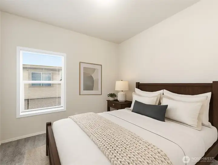 Bright and inviting second bedroom offers a comfortable space for guests or quiet relaxation. (Photo virtually staged)