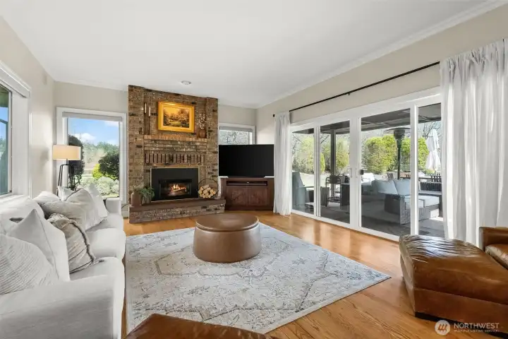 Family room right off the kitchen with another fireplace and to the right is a slider to the deck/backyard.