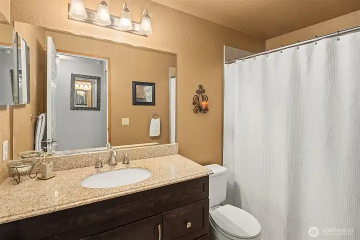 Full hall bath with granite counter.