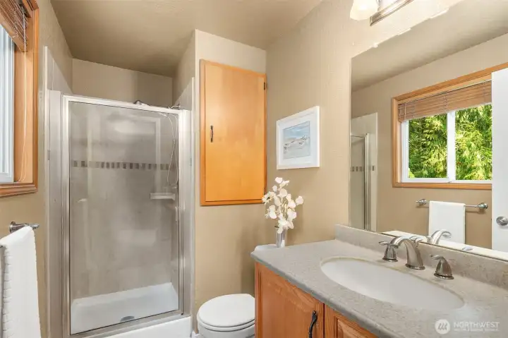 En-suite Primary bathroom with quartz counter and wall storage cabinet.