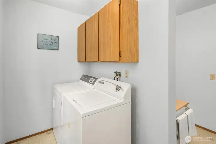Full size washer and dryer with cabinet storage.