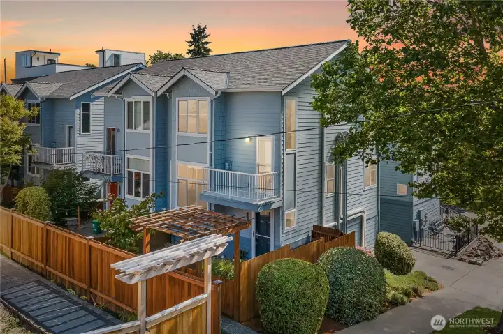 Welcoming corner townhome with charming curb appeal, fenced outdoor space, and attractive architectural details.