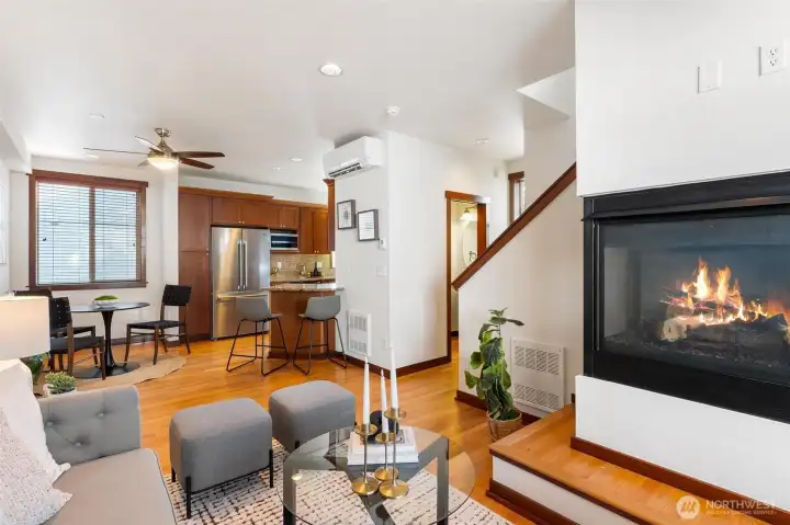 Light-filled main living area featuring hardwood floors, gas fireplace, and an open-concept layout.