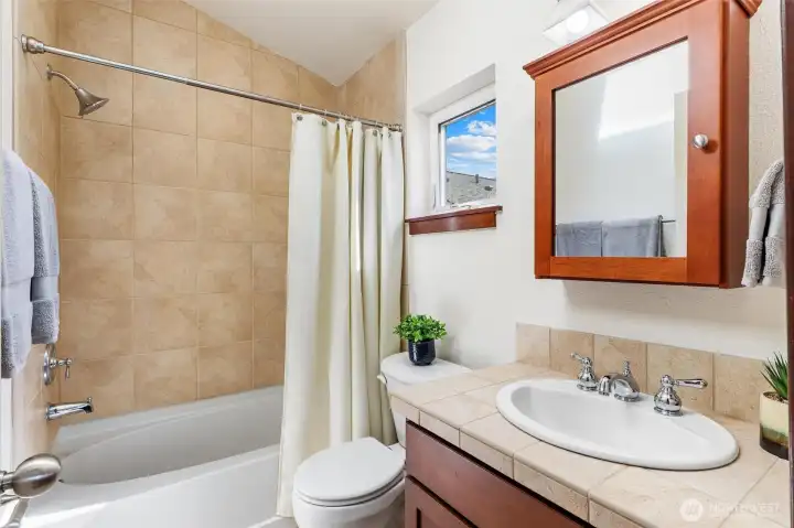 Full bathroom with tiled shower and classic finishes.