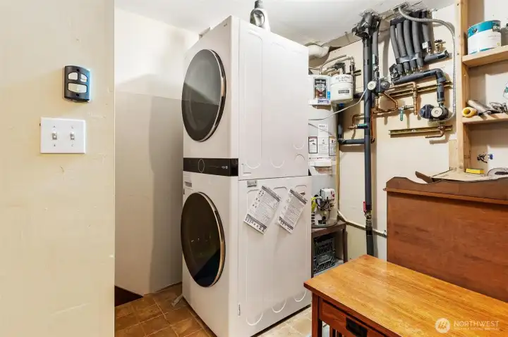 Dedicated laundry area with full-size stacked washer and dryer.