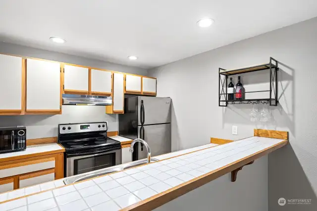 Kitchen features Wood Flooring, Stainless Appliance Set, and Eating Bar.