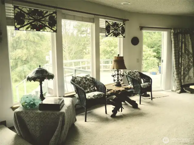 Living room with expansive windows looking out to an amzing deck.