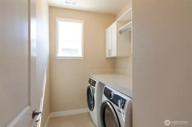 Utility room, complete with newer washer and dryer plus added cabinetry and folding shelf.